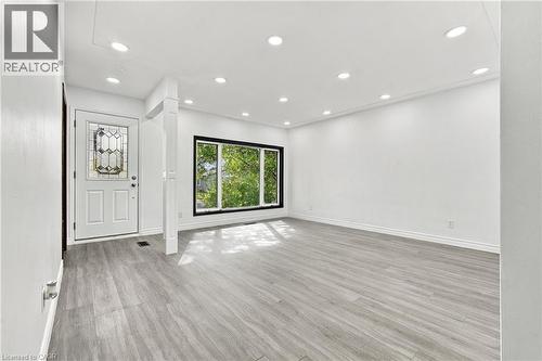 Bright interior space featuring wood-finish flooring, recessed lighting, and a front entry door with decorative glass inserts - 246 Hillcrest Road, Cambridge, ON 