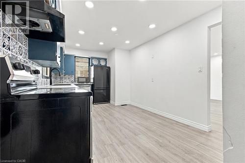 Kitchen featuring light wood-finish flooring, recessed lighting, black range, and black refrigerator - 246 Hillcrest Road, Cambridge, ON 