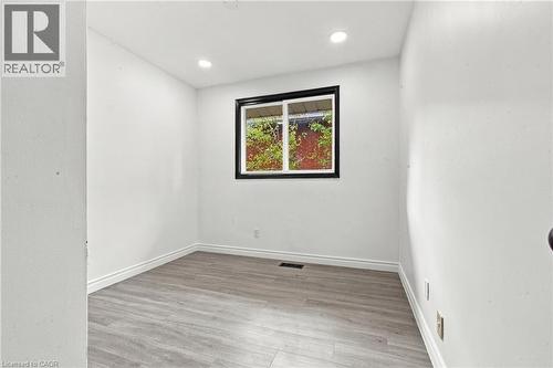 Recessed lighting, wood-finish flooring, white wall finishes, and a dark-framed window - 246 Hillcrest Road, Cambridge, ON 