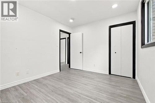 Recessed ceiling lighting, light wood-finish flooring, white walls, and black-trimmed bi-fold closet doors - 246 Hillcrest Road, Cambridge, ON 