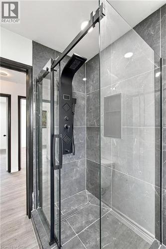 Glass-enclosed shower with a black multi-function shower panel and integrated niche - 246 Hillcrest Road, Cambridge, ON 