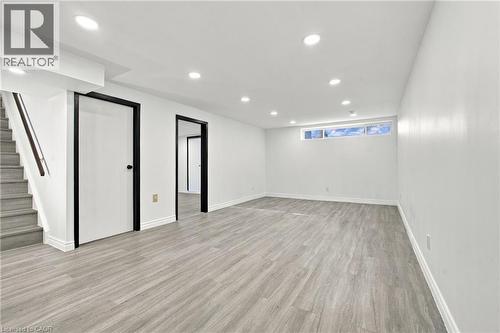 Expansive room featuring wood-finish flooring, recessed lighting, and white walls - 246 Hillcrest Road, Cambridge, ON 