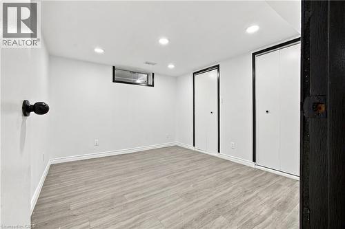 Recessed lighting, wood-finish flooring, white walls, two bi-fold closet doors, and a functional window - 246 Hillcrest Road, Cambridge, ON 