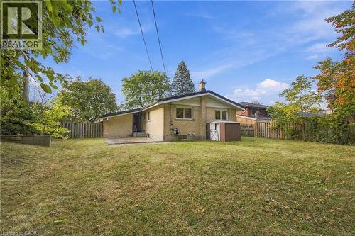 Expansive lawn area with a privacy fence, mature trees, and a concrete patio - 246 Hillcrest Road, Cambridge, ON 