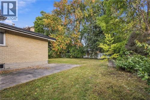Expansive backyard featuring a mature treeline, established shrubbery, and a paved patio area - 246 Hillcrest Road, Cambridge, ON 