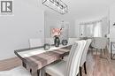 Sophisticated dining space showcasing a wood-finish table with geometric base, paired with upholstered dining chairs featuring nailhead trim - 164 Wilson Street, Hamilton, ON 