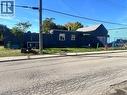Dark-toned exterior siding, rectangular window configurations, and perimeter fencing - 150 Princess Street, Hamilton, ON 