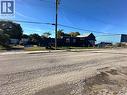 Single-story exterior featuring blue siding, a peaked roofline, and perimeter chain-link fencing - 150 Princess Street, Hamilton, ON 