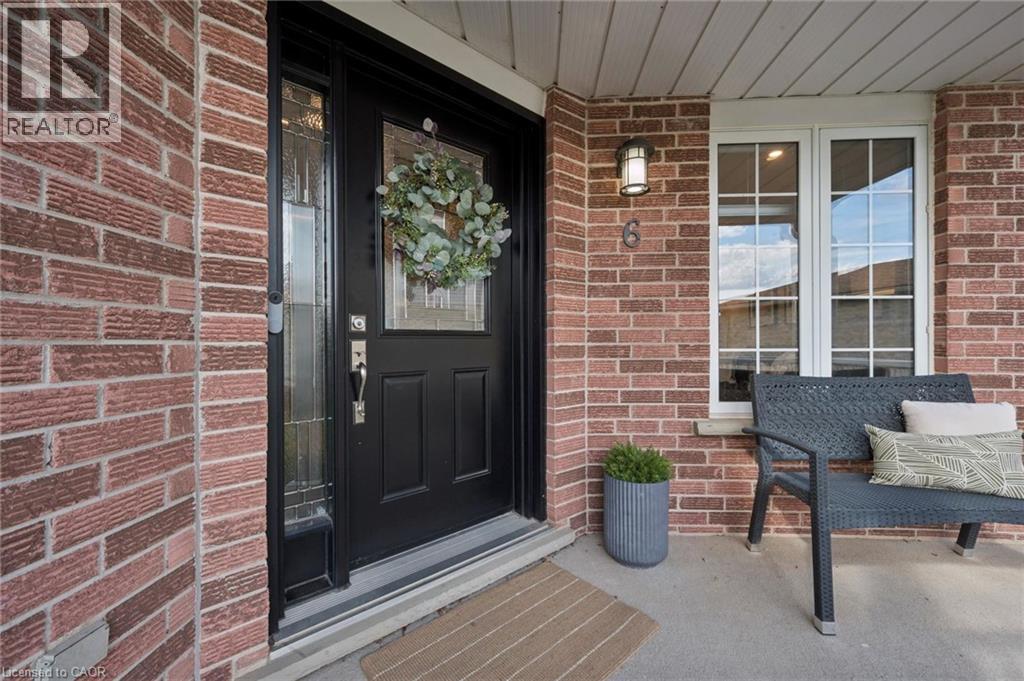 Brick exterior with a dark-paneled entry door, transom, and sidelight - 6 Branwood Place, Kitchener, ON