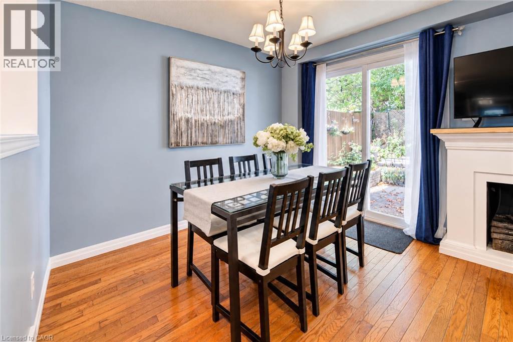 Wood-finish flooring, sliding glass patio door, built-in fireplace, and a chandelier fixture - 327 Oprington Place, Kitchener, ON