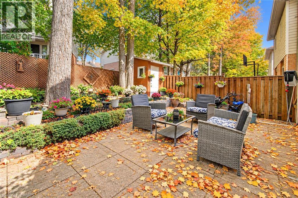 Expansive patio area featuring paving stones and a privacy fence - 327 Oprington Place, Kitchener, ON