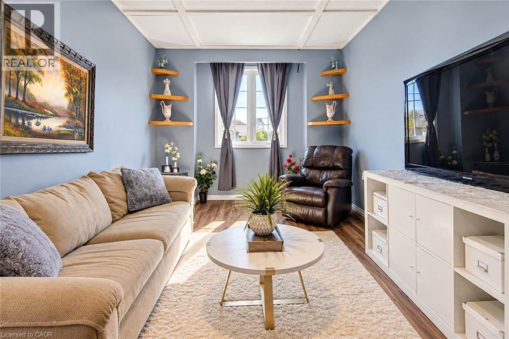 Recessed ceiling paneling, wood-finish flooring, corner shelving, and a built-in media console - 327 Oprington Place, Kitchener, ON