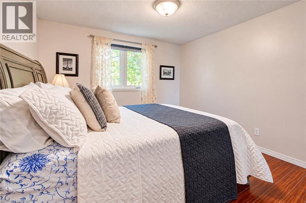 Wood-finish flooring, white walls, and a window with white trim - 327 Oprington Place, Kitchener, ON