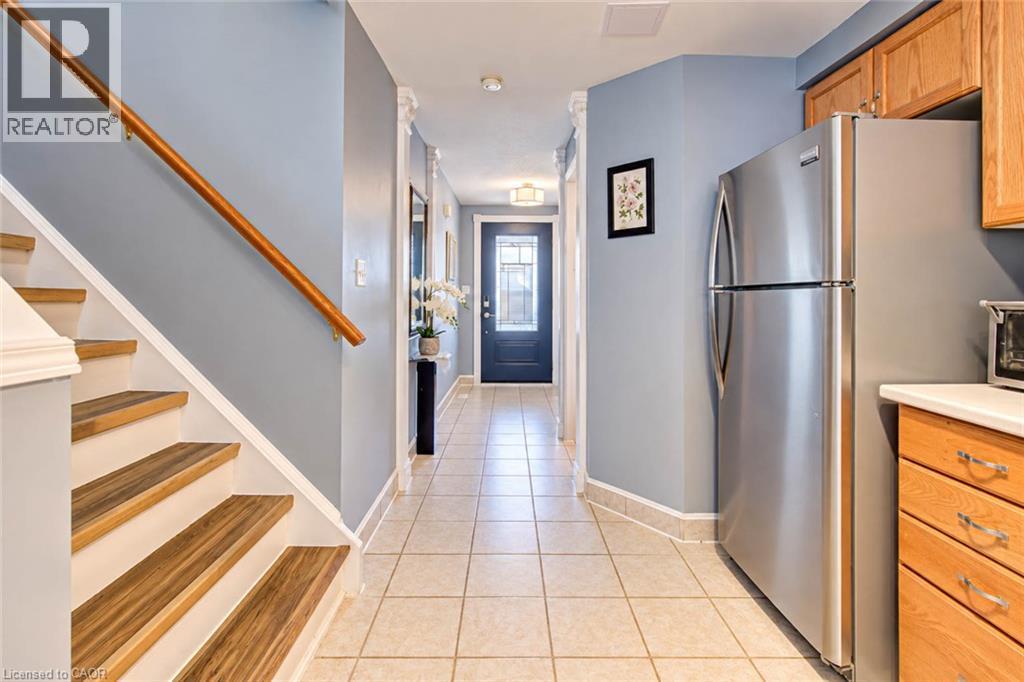 Wood-finish staircase with white risers and a wood handrail - 327 Oprington Place, Kitchener, ON