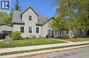 Gabled roofline, light gray siding, prominent front yard, paved driveway, detached garage with dark gray siding - 74 Selkirk Street, Cambridge, ON 