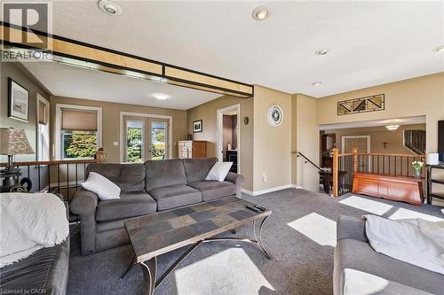 Carpeted living area featuring recessed lighting, a half-wall with dark metal spindles, and a wood handrail - 74 Selkirk Street, Cambridge, ON 