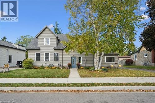 Two-story residence featuring light gray siding, a prominent front gable, and a vibrant blue entry door - 74 Selkirk Street, Cambridge, ON 