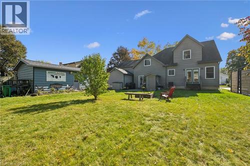 Expansive lawn featuring a detached accessory structure, a separate storage shed, rear patio doors, and a wood privacy fence - 74 Selkirk Street, Cambridge, ON 