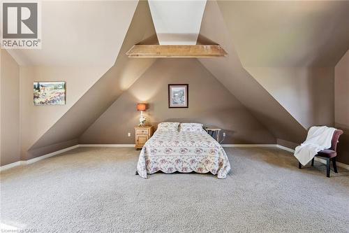 Expansive carpeted room featuring sloped ceilings, a prominent exposed beam, and neutral wall tones - 74 Selkirk Street, Cambridge, ON 