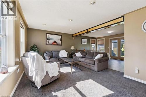 Carpeted living area with multiple windows, recessed lighting, and a partial wood-finish beam detail - 74 Selkirk Street, Cambridge, ON 
