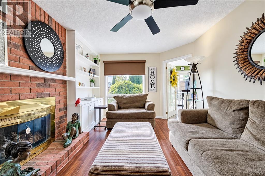 Bright family room features large window, gas fireplace & built-in shelves. - 11 Peregrine Crescent, Cambridge, ON