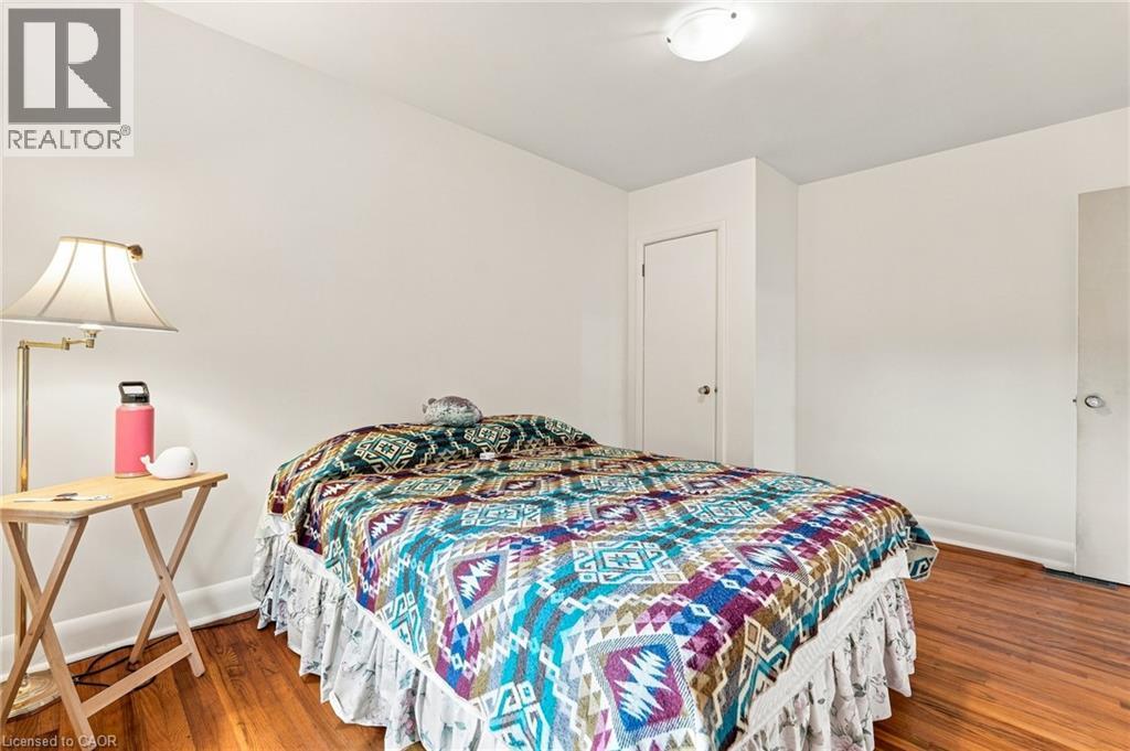 Room featuring wood-finish flooring, neutral walls, two interior doors, and a ceiling-mounted light fixture - 241 East 44Th Street, Hamilton, ON