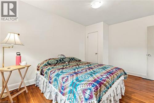 Room featuring wood-finish flooring, neutral walls, two interior doors, and a ceiling-mounted light fixture - 241 East 44Th Street, Hamilton, ON 