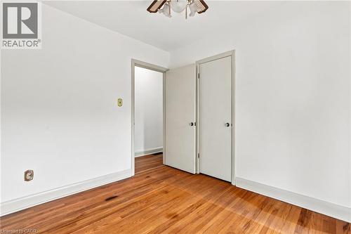 Wood-finish flooring, neutral wall tones, multi-panel doors, and an overhead flush-mount light fixture - 241 East 44Th Street, Hamilton, ON 