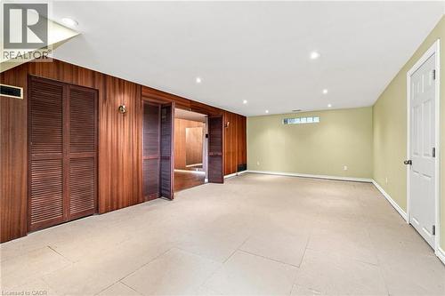 Interior space featuring wood-panel wall treatments, louvered closet doors, recessed ceiling lighting, and large-format tile flooring - 241 East 44Th Street, Hamilton, ON 