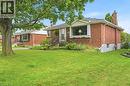 Exterior featuring red brick masonry, a brick chimney, a front bay window, and a wrought-iron entrance railing - 241 East 44Th Street, Hamilton, ON 
