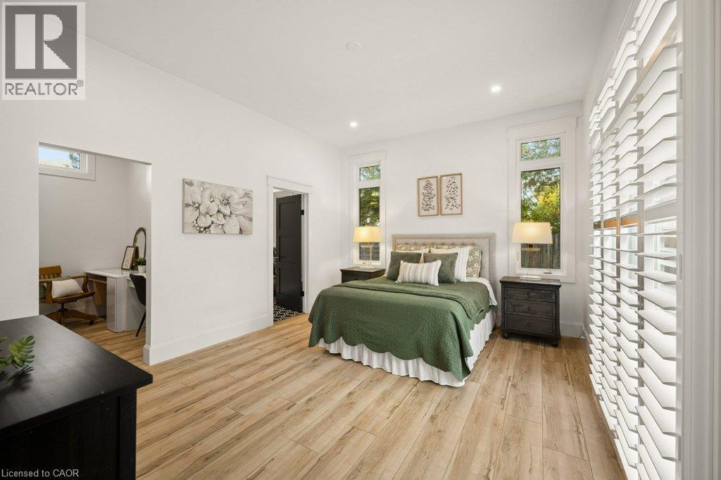 Room featuring wood-finish flooring, recessed lighting, and windows outfitted with plantation shutters - 361 Lee Circle, Waterloo, ON