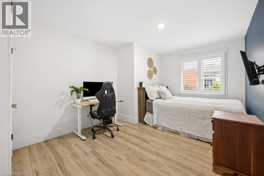 Wood-finish flooring, recessed lighting, and white plantation shutters - 361 Lee Circle, Waterloo, ON