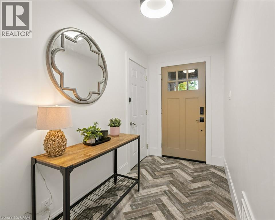 Entryway featuring herringbone-patterned flooring, solid door with glass pane detail, and modern flush-mount lighting - 361 Lee Circle, Waterloo, ON