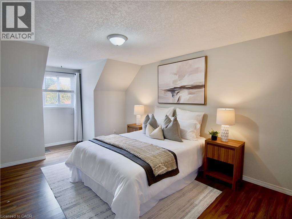 Bedroom featuring wood-finish flooring, recessed wall alcoves, and a flush-mount ceiling light fixture - 449 Exmoor Street, Waterloo, ON