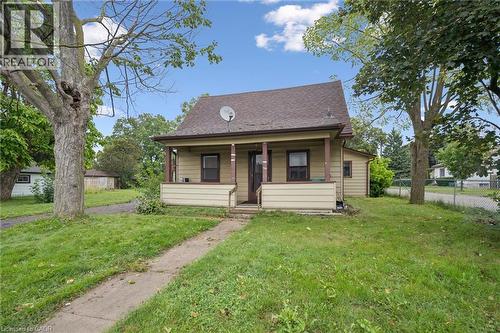 Single-story residence featuring horizontal siding, a pitched roof, a covered front porch with wooden support posts, and a concrete walkway - 1279 Hamilton Street, Cambridge, ON 
