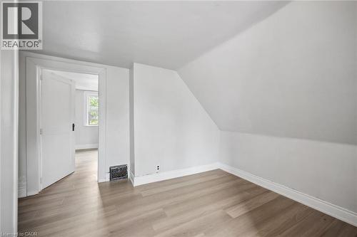 Interior space featuring vaulted ceilings, wood-finish flooring, and a traditional door with antique-style hardware - 1279 Hamilton Street, Cambridge, ON 
