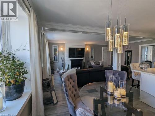 Interior space featuring wood-finish flooring, a multi-pendant glass chandelier, crown molding, and a fireplace with a mantel - 326 Ottawa Street, Hamilton, ON 