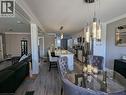 Kitchen featuring a stone-topped island with seating, wood-finish flooring, crown molding, and decorative cylindrical pendant lighting - 326 Ottawa Street, Hamilton, ON 