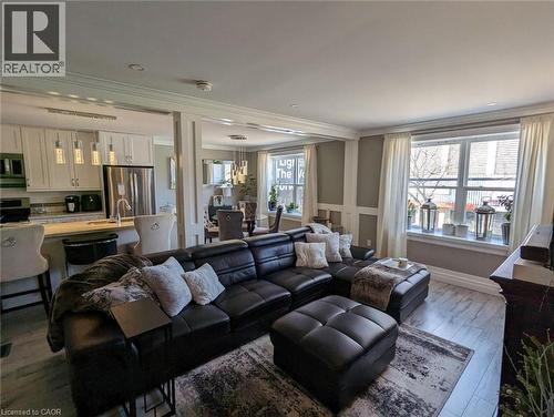 Open-concept kitchen featuring white shaker-style cabinetry, stainless steel appliances, and a breakfast bar - 326 Ottawa Street, Hamilton, ON 