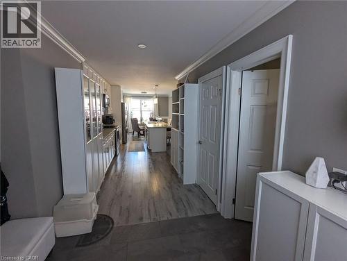 Hallway featuring wood-finish flooring, white built-in cabinetry, crown molding, and recessed lighting - 326 Ottawa Street, Hamilton, ON 