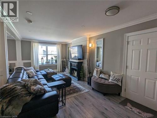 Living area featuring wood-finish flooring, crown molding, recessed lighting, and a fireplace with a custom-paneled hearth surround - 326 Ottawa Street, Hamilton, ON 