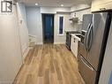 Kitchen featuring wood-finish flooring, white shaker-style cabinetry, stainless steel appliances, recessed ceiling lighting, and a vertical window - 197 Ferguson Avenue S, Hamilton, ON 