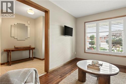 Wood-finish flooring, white plantation shutters, and a natural wood cased doorway - 53 Bastille Street, Hamilton, ON 