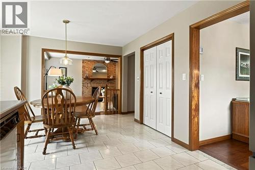 Tiled flooring, natural wood door trim and casing, bifold closet doors, and a brick fireplace surround - 53 Bastille Street, Hamilton, ON 