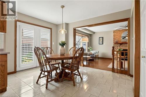 Ceramic tile flooring, glass-paneled double doors, neutral wall tones, wood-trimmed entry, and a brick fireplace - 53 Bastille Street, Hamilton, ON 