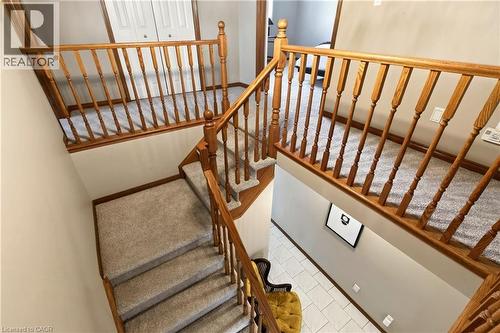 Staircase featuring wood railings with balusters, carpeted stairs, and neutral wall tones - 53 Bastille Street, Hamilton, ON 