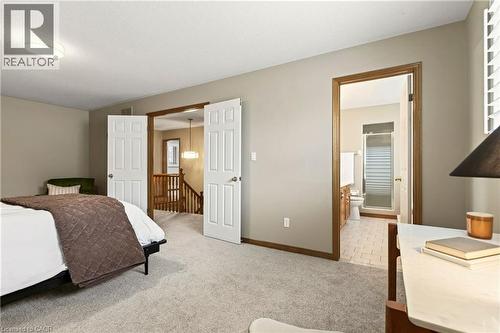 Neutral wall tones, wall-to-wall carpeting, white six-panel interior doors, and wood-trim door casings - 53 Bastille Street, Hamilton, ON 