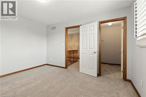 Neutral wall tones, carpeted flooring, white six-panel interior doors, and window shutters - 53 Bastille Street, Hamilton, ON 