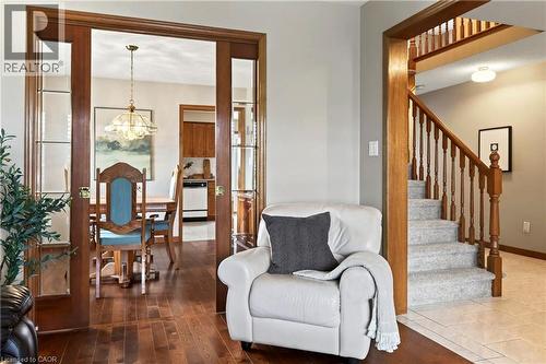 Hardwood flooring, wood-trimmed French doors with glass panes, and a staircase featuring wood railings and balusters - 53 Bastille Street, Hamilton, ON 