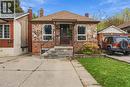 Exterior featuring stone and brick facade, gabled roof, concrete driveway, and covered front porch with metal railings - 81 East 23Rd Street, Hamilton, ON 